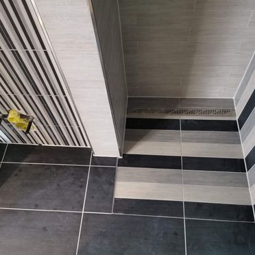 Kombinasjon av små, store og smalstripede fliser i renovert baderom
