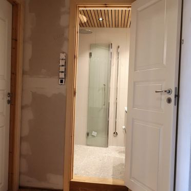Renovert baderom sett fra gang som er under oppussing