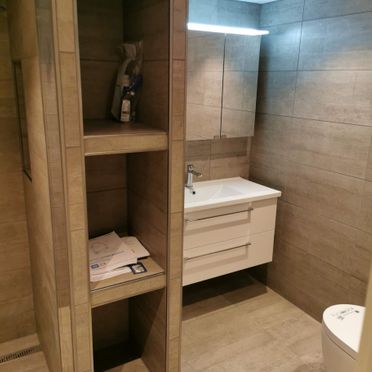 Renovert baderom med innebygget oppbevaring og vaskeservant med speil