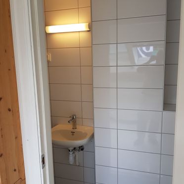 Hvite fliser på vegg i renovert baderom