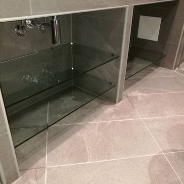 Renovert bad med innebygget vask med smarte glasshyller til oppbevaring under