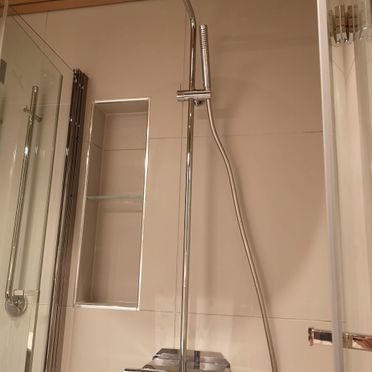 Dusj med stort dusjhode og storformatflis på vegg