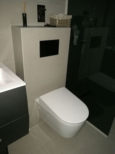 Vegghengt toalett i renovert, grått baderom på Jar