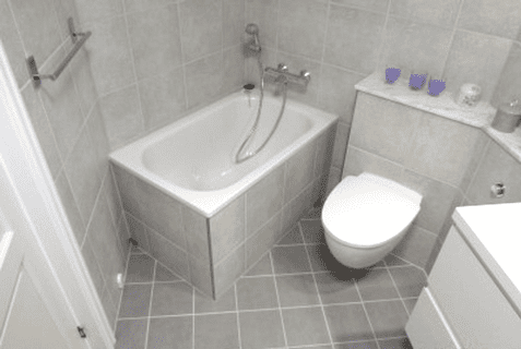 Renovert baderom med lys grå flis på vegger, gulv og badekar