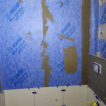 Bad under renovering med foliemembran på vegg
