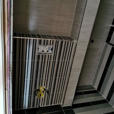 Kreativ bruk av fliser i tynne og tykkere striper i renovert baderom