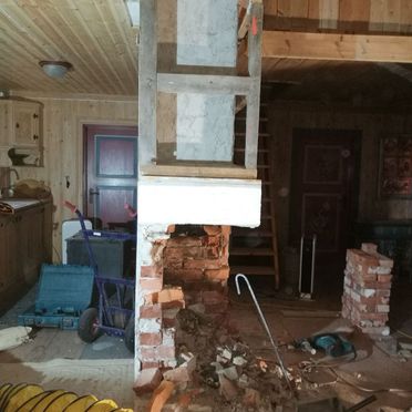Gammel peis og pipe i bolig med trepanel revet