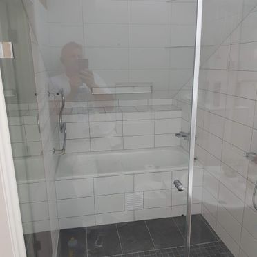 Renovert bad med dusjsone med badekar bak glassdører