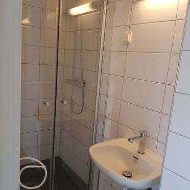 Hvite fliser på vegg i renovert baderom